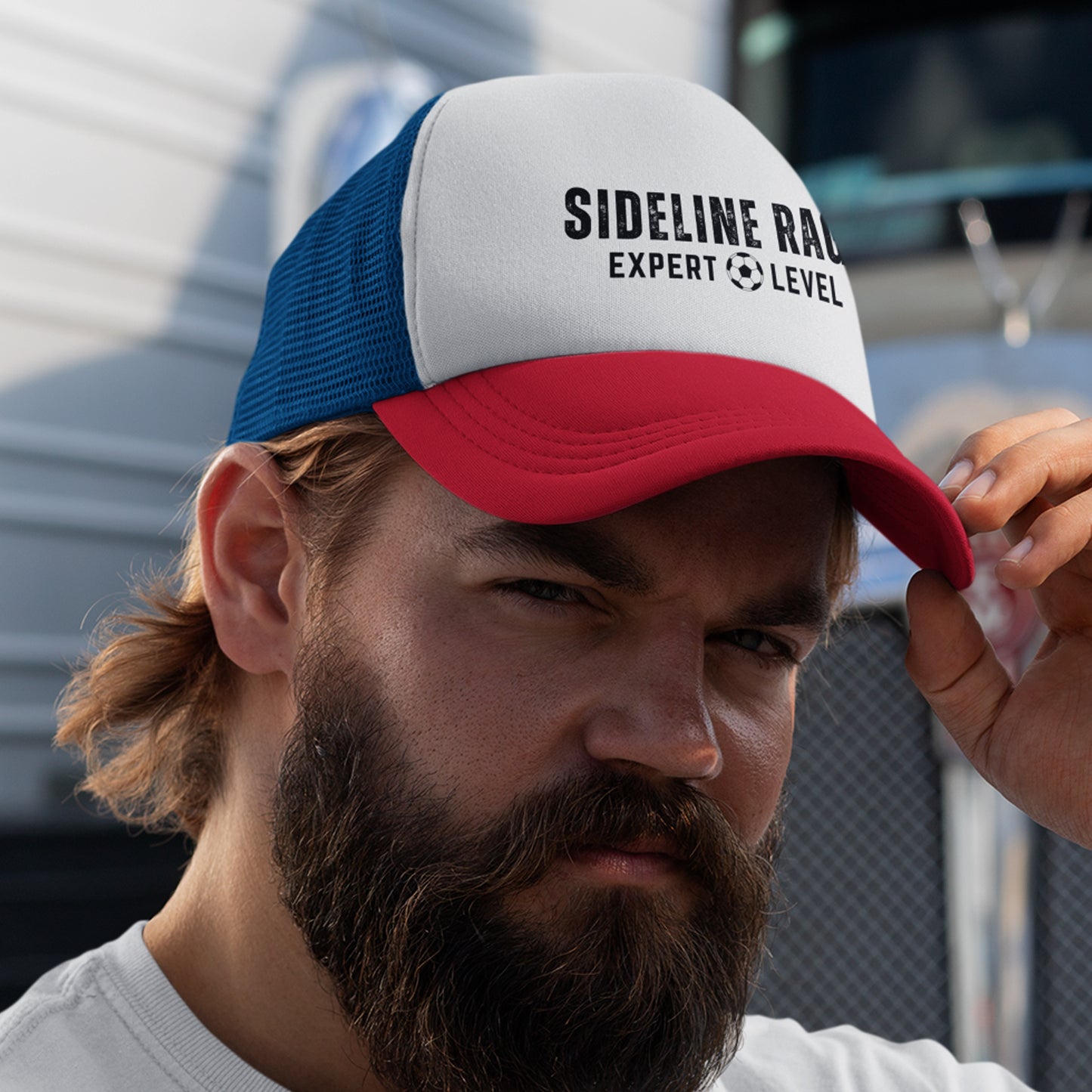 Soccer Dad wearing 'Sideline Rage' Trucker cap, in front of a truck.